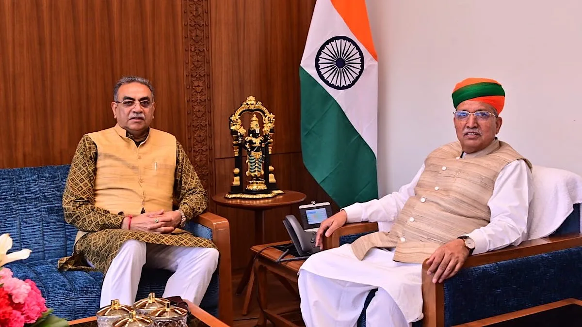 Shri Arjun Ram Meghwal in an official consultation beside the national flag.