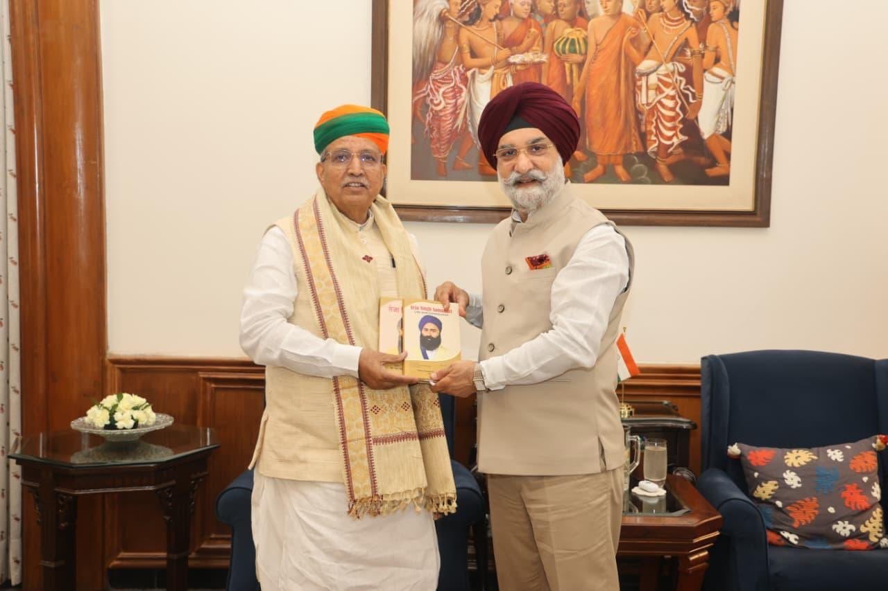 Shri Arjun Ram Meghwal receiving a publication during an official meeting at the Ministry of Law and Justice.