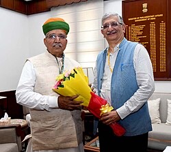 At the Ministry of Parliamentary Affairs, beside the board recording holders of the office. Low-resolution archival image.